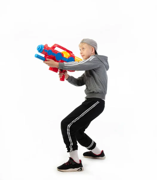 Un niño con una pistola de agua aislada sobre un fondo blanco — Foto de Stock