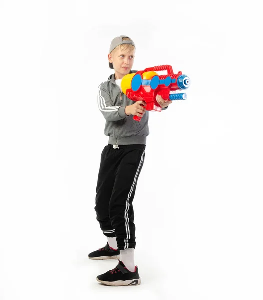 Un niño con una pistola de agua aislada sobre un fondo blanco — Foto de Stock