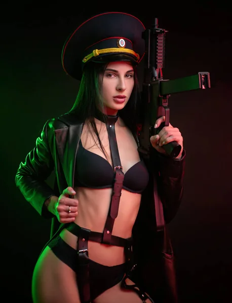 Morena caliente desnuda en un cinturón con un arma y una gorra militar —  Fotos de Stock