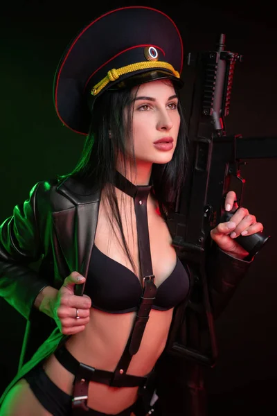 Hot brunette naked in a belt with a weapon and a military cap — Stock Photo, Image