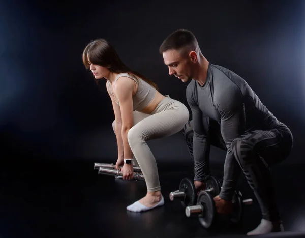 Een man en een vrouw zijn bezig met sport in de handen van halters — Stockfoto