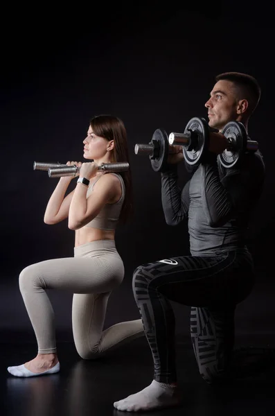 Un hombre y una mujer se dedican a los deportes en manos de pesas — Foto de Stock