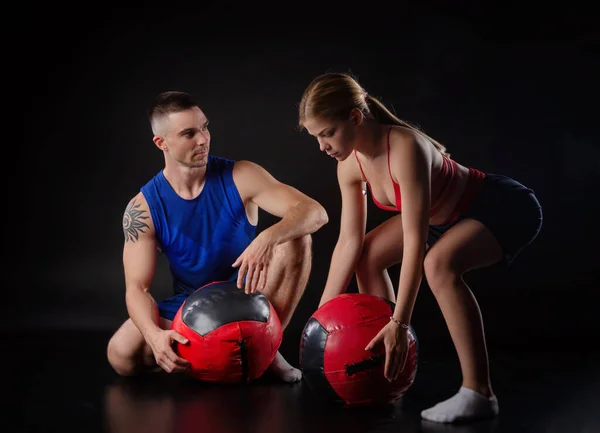 Un chico y una chica de tren con una bola de peluche pesado — Foto de Stock