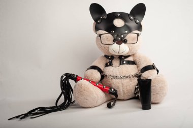 Deri kemer takmış oyuncak ayı hafif arka planda bdsm oyunları için aksesuar.