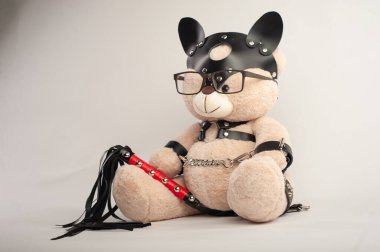 Deri kemer takmış oyuncak ayı hafif arka planda bdsm oyunları için aksesuar.