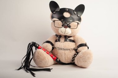 Deri kemer takmış oyuncak ayı hafif arka planda bdsm oyunları için aksesuar.