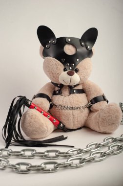 Deri kemer takmış oyuncak ayı hafif arka planda bdsm oyunları için aksesuar.