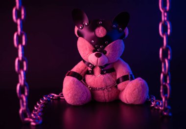 Deri kemer takmış oyuncak ayı BDSM oyunları için aksesuar neon ışıklı karanlık bir arka planda