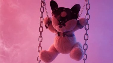 Oyuncak ayı zincire vurulmuş bdsm aksesuarları neon ışığı altında duman içinde