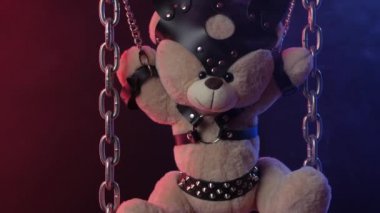Oyuncak ayı zincire vurulmuş bdsm aksesuarları neon ışığı altında duman içinde