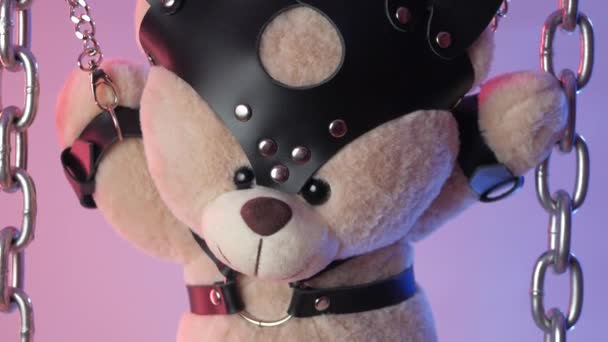 Teddybär hängt an Ketten in Neonlicht im Rauch — Stockvideo