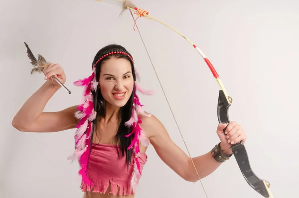 Slender girl in an Amazon costume with a bow and arrow in her hands — Stock Photo, Image