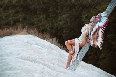 Doğada çıplak poz veren Amerika 'nın yerli halklarının suretinde bir kadın.