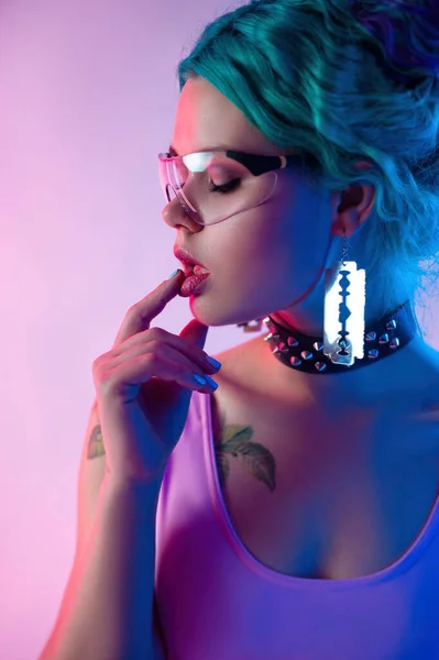 Retrato de uma mulher brilhante com cabelo azul em óculos transparentes em luz de néon — Fotografia de Stock