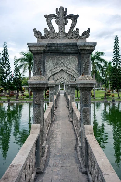 印度尼西亚巴厘岛乌戎潘公园的池塘上华丽的石雕桥 — 图库照片