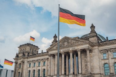 Alman bayrakları Reichstag binasında rüzgarda sallanıyor - Alman parlamentosunun merkezi (Deutscher Bundestag), Berlin, Almanya