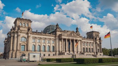 Alman bayrakları Reichstag binasında rüzgarda sallanıyor - Alman parlamentosunun merkezi (Deutscher Bundestag), Berlin, Almanya