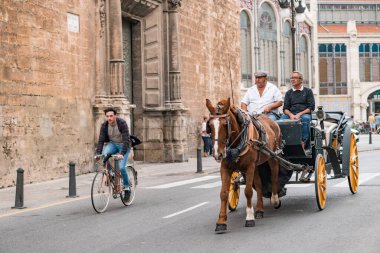 Valencia, İspanya - 28 Ekim 2019: Eski Valencia şehri turu sırasında at arabalı bir turist. Arkaplanda Mercado merkez binası yer almaktadır.