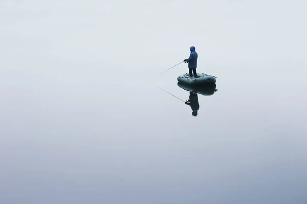 Balıkçı göl kenarında ufak bir botla