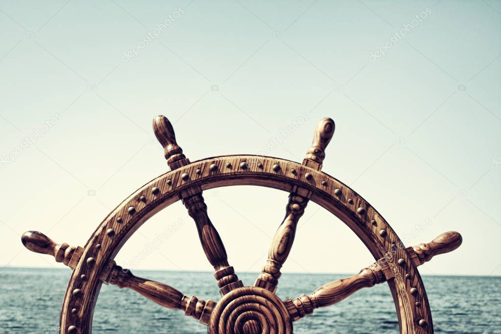 Old Vintage Wooden Helm Wheel on sea background