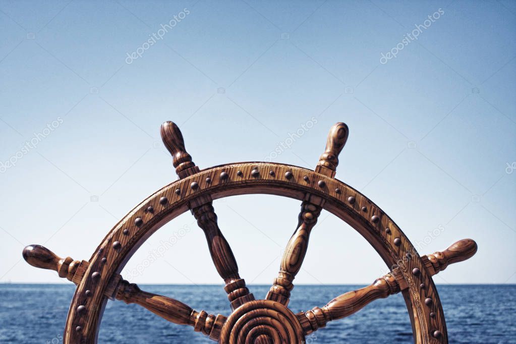 Old Vintage Wooden Helm Wheel on sea background