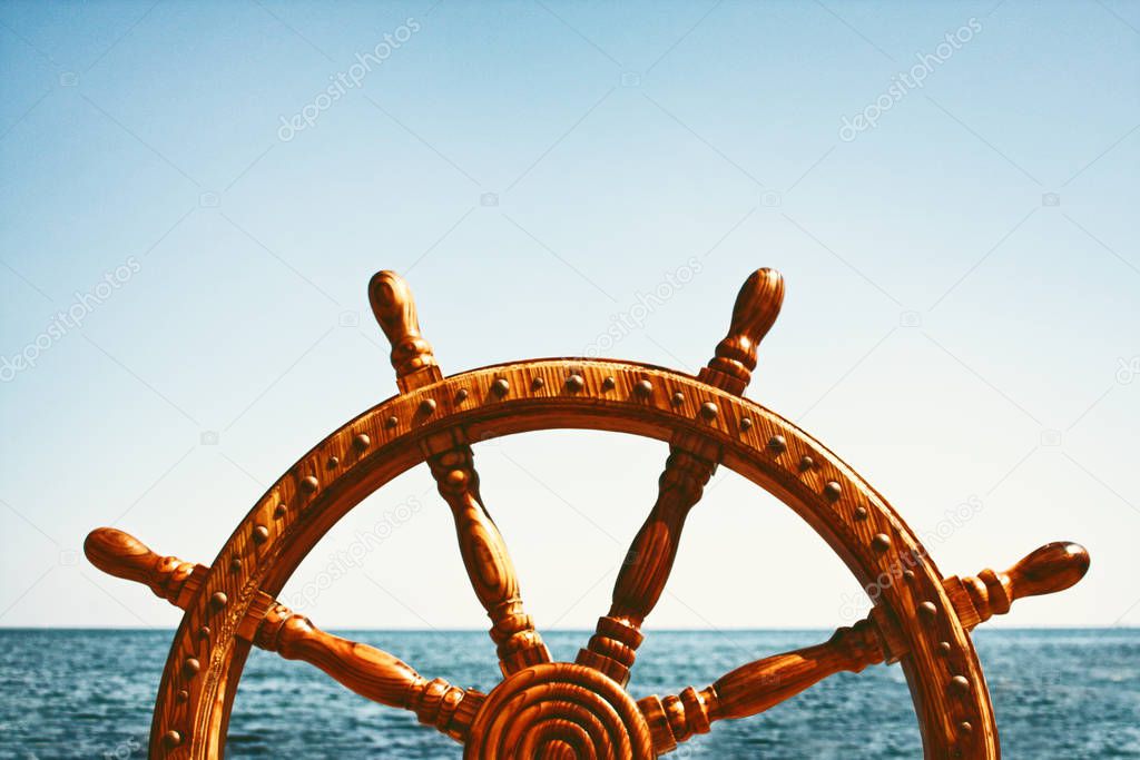 Old Vintage Wooden Helm Wheel on sea background