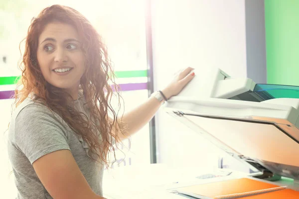 A young student at a copy center taking some copies for her final exams