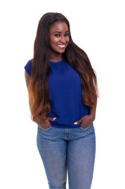 Gülümseyen ve beyaz arka plan üzerinde izole kot pantolon ceplerinde ellerini tutarak kameraya bakarak güzel genç Afrika kadın