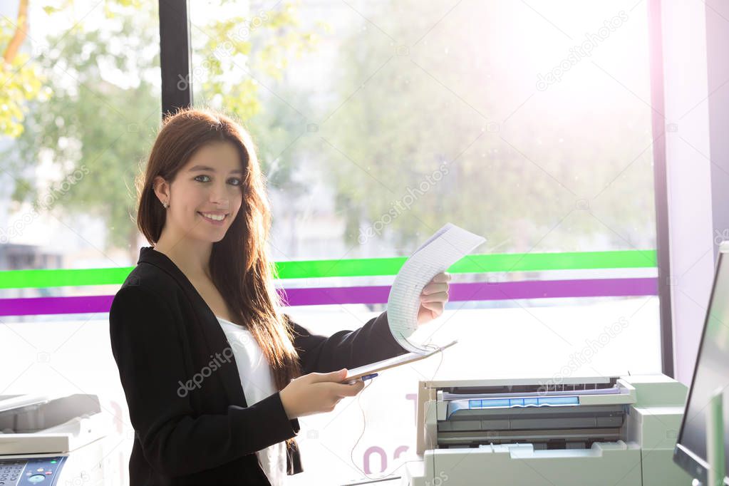 young student at copy center taking some copies for final exams 