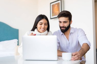 Bir kadın ve bir erkek birlikte bir dizüstü bilgisayarda çalışır. Onlar bir şey kendi daire için görüşüyorlar. Internet üzerinde önemli bir şey için arıyoruz.
