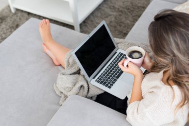 Genç kadın laptop ve kahve ile rahatlatıcı