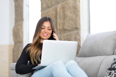 Güzel genç kadın evde dizüstü bilgisayarında rahatlatıcı