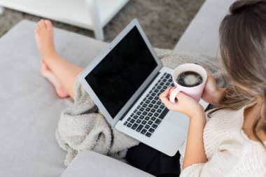 Güzel genç kadın evde dizüstü bilgisayarında rahatlatıcı