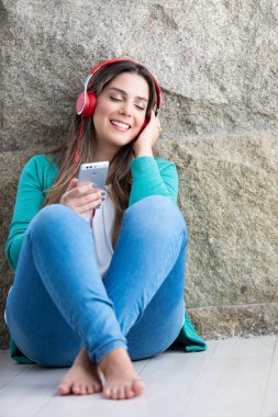 Güzel genç kadın bazı müzik dinlerken kanepede rahatlatıcı