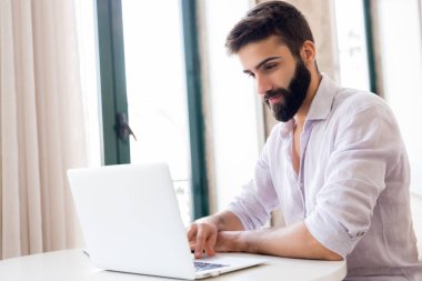 Evden dizüstü bilgisayarda çalışan adam. Finansal veri sayma.