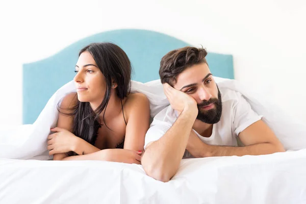 Young depressed couple in bed