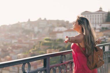 Porto City, Portekiz gün batımı sırasında nehir ve ünlü demir Köprüsü ile eski şehirde güzel manzara görünümü zevk genç kadın turist