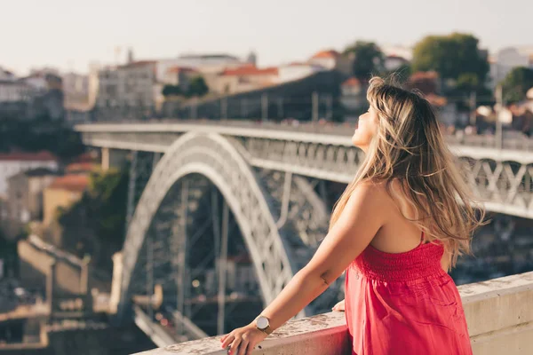 Porto City, Portekiz gün batımı sırasında nehir ve ünlü demir Köprüsü ile eski şehirde güzel manzara görünümü zevk genç kadın turist