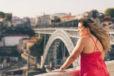 Porto City, Portekiz gün batımı sırasında nehir ve ünlü demir Köprüsü ile eski şehirde güzel manzara görünümü zevk genç kadın turist