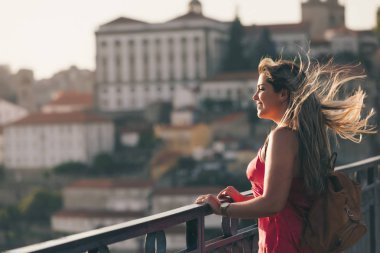 Porto City, Portekiz gün batımı sırasında nehir ve ünlü demir Köprüsü ile eski şehirde güzel manzara görünümü zevk genç kadın turist