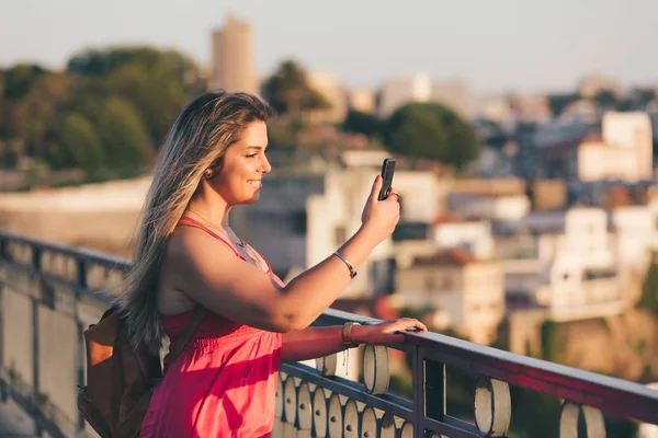 ポルトガル ポルト市の夕日の間に川と有名な鉄橋と旧市街の美しい風景を楽しむ若い女性観光客 — ストック写真