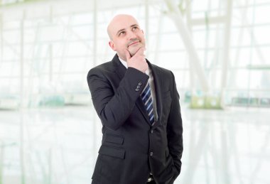 Genç bir iş adamı, ofiste düşünüyor.