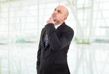 Genç bir iş adamı, ofiste düşünüyor.