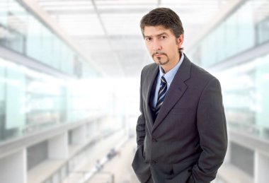 Genç bir iş adamı, ofiste düşünüyor.