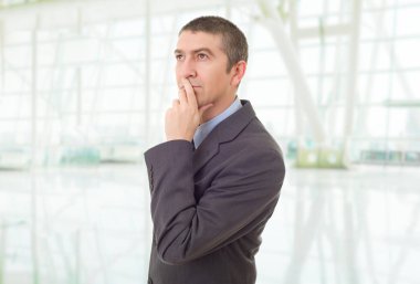 Genç bir iş adamı, ofiste düşünüyor.