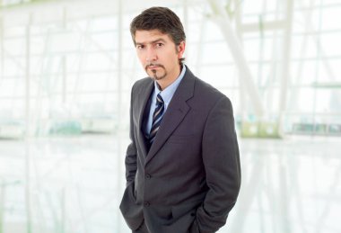 Genç bir iş adamı, ofiste düşünüyor.