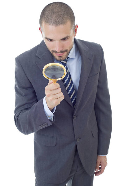 Isolated young business man with magnifying glass