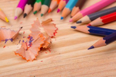 Ahşap masa üzerinde yontulmuş talaşlı ahşap renkli kalemler.