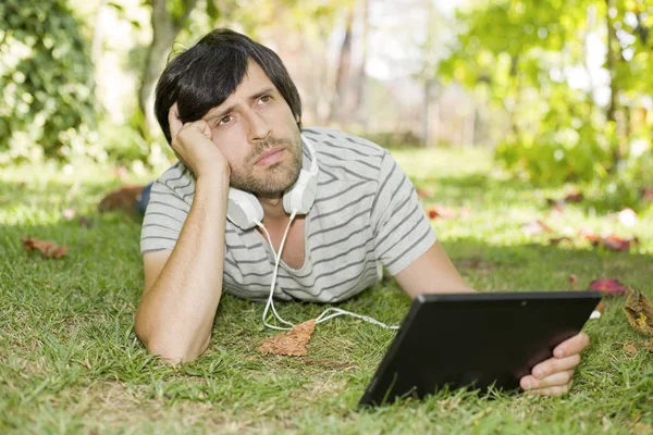 Jonge Man Ontspannen Met Een Tablet Luisteren Muziek Met Koptelefoon — Stockfoto