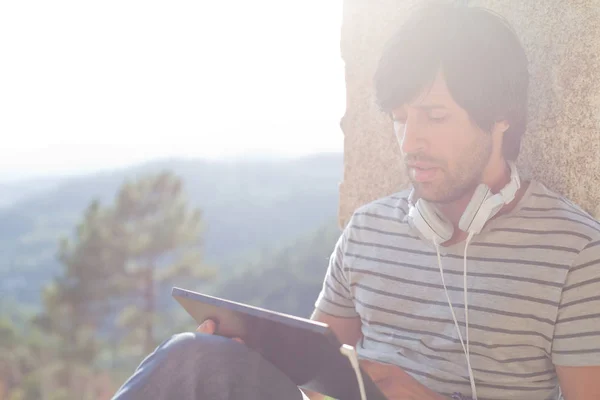 Młody Człowiek Pracujący Tabletem Muzyka Odsłuchowa Słuchawkami Outdoor — Zdjęcie stockowe